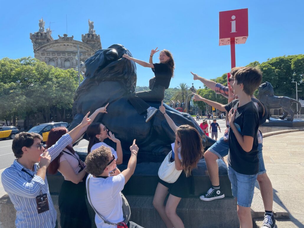 A group beside a lion sculpture.