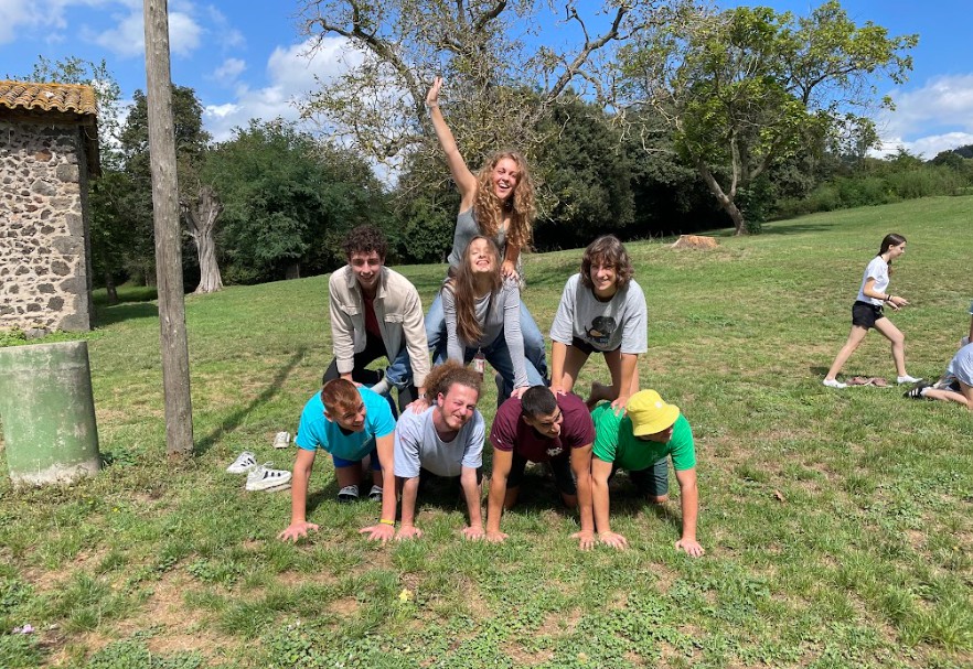 A group forming a human pyramid on the grass.